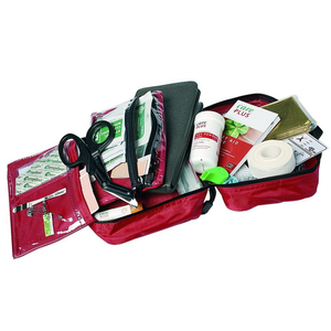 Een geopende rode Care Plus First Aid Kit eerstehulptas, met daarin diverse medische hulpmiddelen zoals een verbandschaar, pleisters, rollen tape, een nooddeken, een gids voor eerste hulp, veiligheidsspelden en een groen fluitje, overzichtelijk uitgespreid op een witte achtergrond.