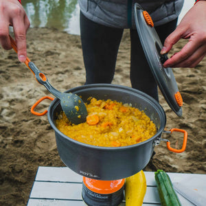 GSI Outdoors Halulite Pot 3.2L grijze aluminium kookpan met oranje handgrepen, deksel en opscheplepel tijdens kamperen