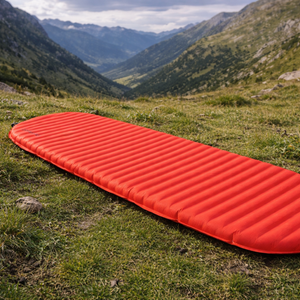 Rode Therm-a-Rest ProLite Apex Heat Wave L slaapmat uitgespreid in een groen alpenlandschap met bergen