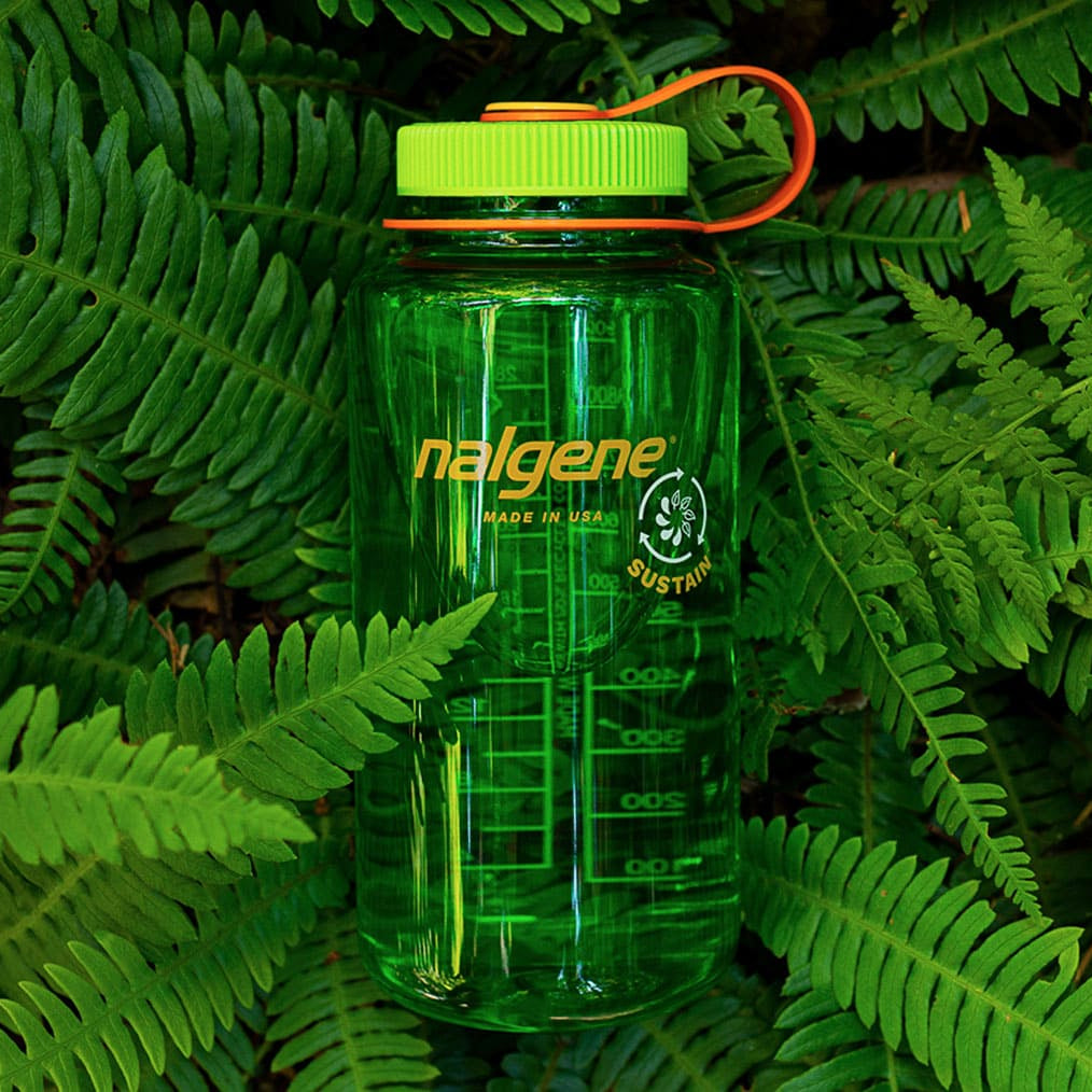 Nalgene Sustain groene waterfles met inhoudsmarkering en oranje lus omringd door groene varens