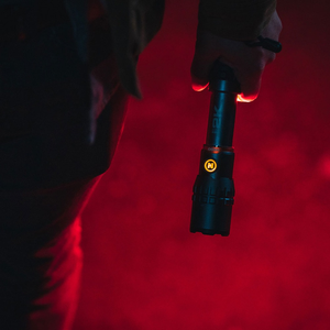 Nebo Edge 2K zwarte aluminium tactical zaklamp met verlichte drukknop en USB-C oplaadbaarheid vastgehouden in het donker