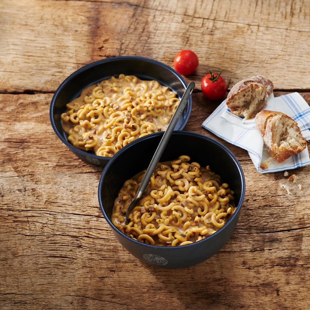 Trek'n Eat Pasta Creamy Mushrooms + Beef bereid in zwarte kommen op houten tafel met tomaten en brood   